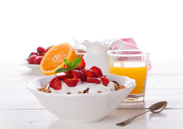 Muesli with strawberries, orange juice, and orange fruit