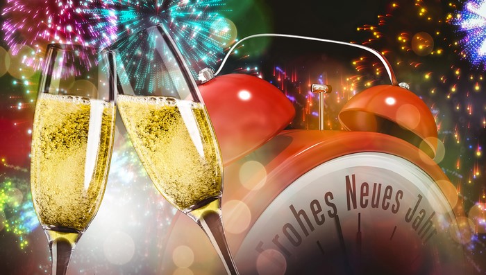 Champagne glasses and alarm clock with fireworks