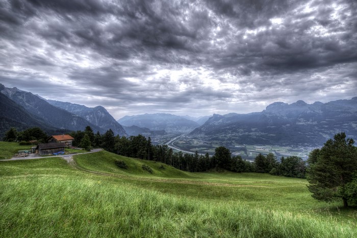 Mountains and valley with houses and cloudy sky