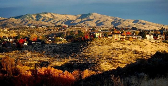 Autumn hillside with houses and mountains