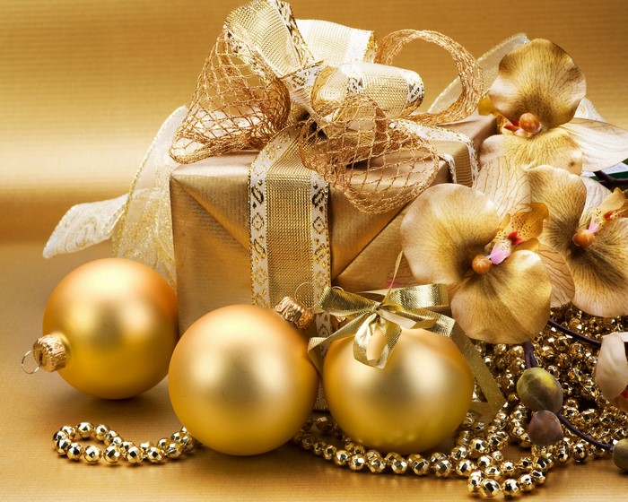 Golden Christmas gift with ornaments and orchids