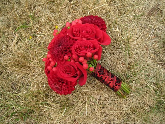 Red roses and dahlias bouquet on dry grass