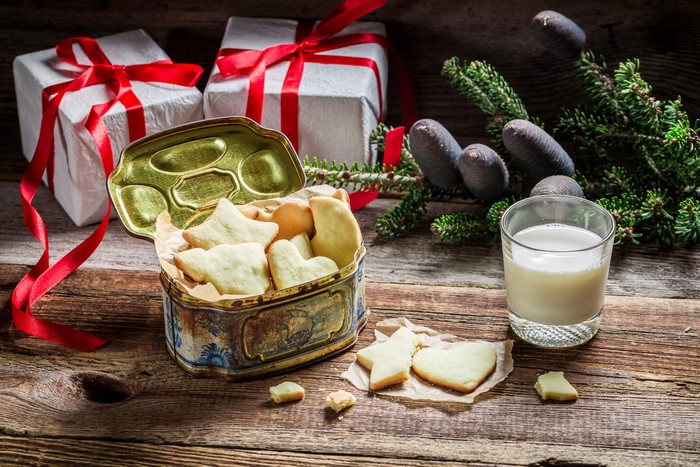 Christmas cookies in a tin with milk and gifts