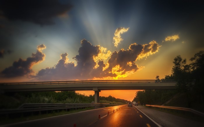 Highway overpass at sunset with dramatic clouds