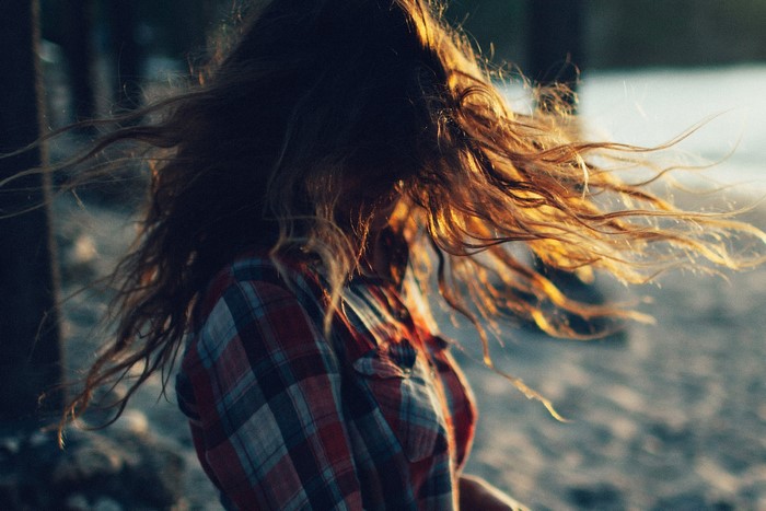 Woman with long brown hair in a plaid shirt