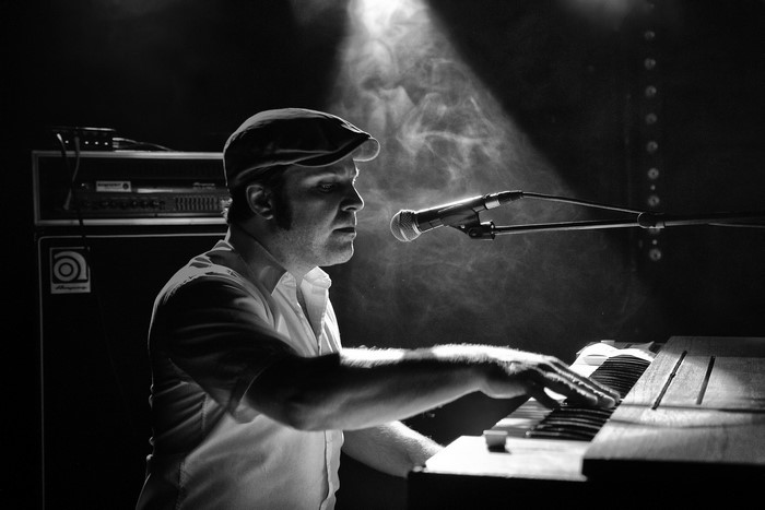 Man playing keyboard with microphone and smoke