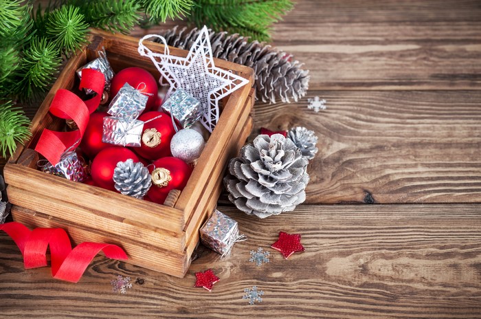 Christmas ornaments in a wooden box with pine cones