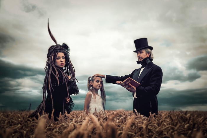 Man in Top Hat Reads to Girl in Field