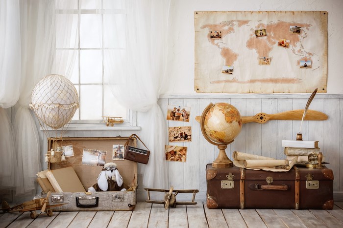 Vintage travel-themed room with globe and suitcase