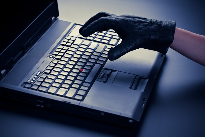 4K Hacker in Black Glove Using Laptop