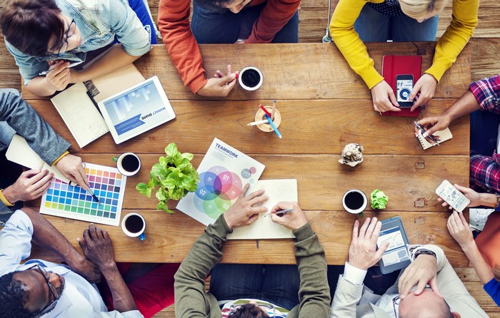 Diverse group of people collaborating around a wooden table