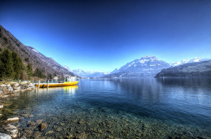 Yellow boat on Lake Lucerne, Switzerland with mountains