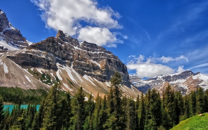 Snow-capped mountains and turquoise lake with pine trees