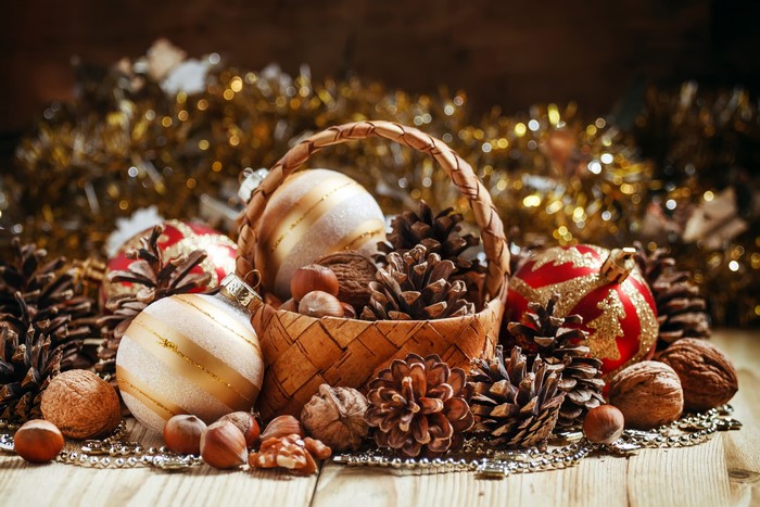 Christmas ornaments, pine cones, and nuts in a basket
