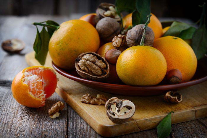 Mandarin oranges and walnuts on a wooden table