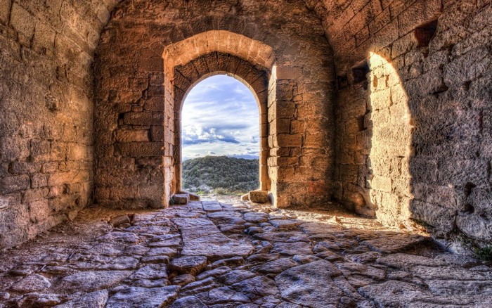 Ancient stone archway overlooking a green landscape