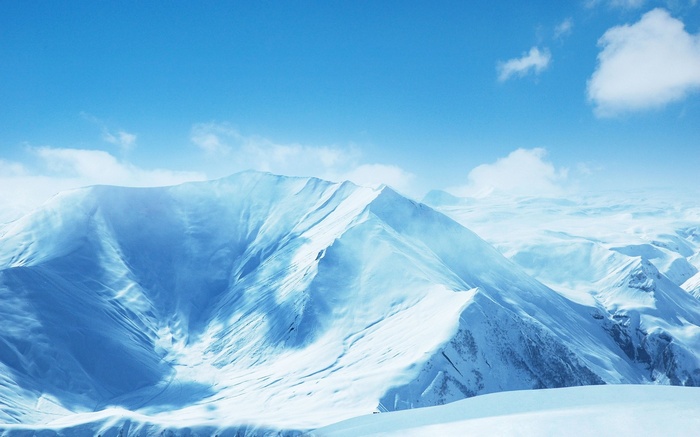 Snow-covered mountains under a blue sky