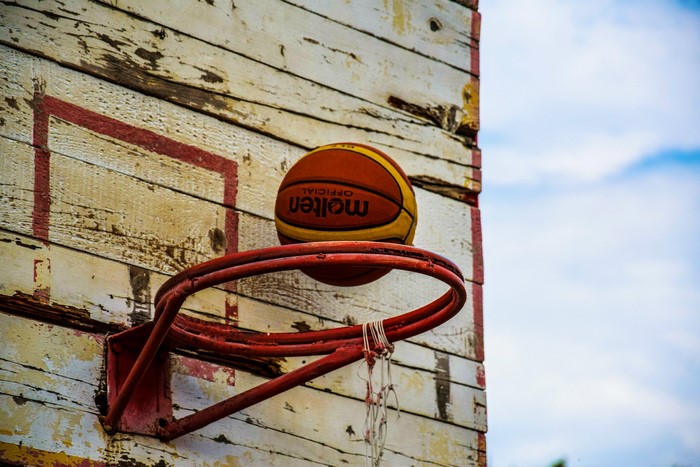 Basketball on a weathered hoop and backboard