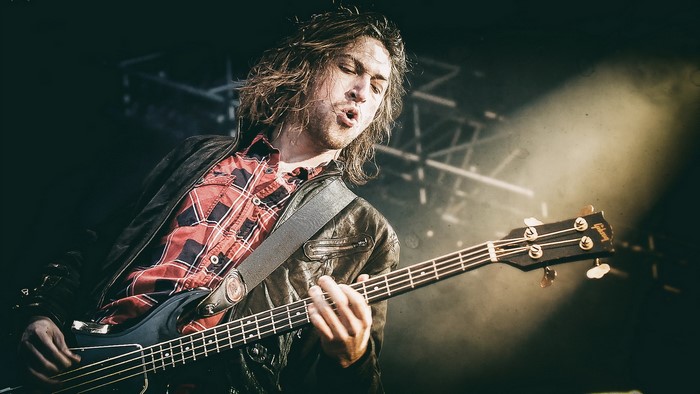 Michael Shuman playing bass guitar on stage