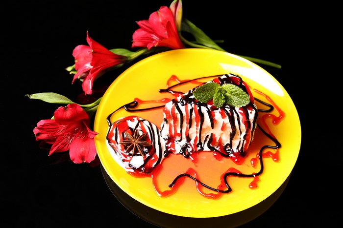 Dessert with red flowers on a yellow plate