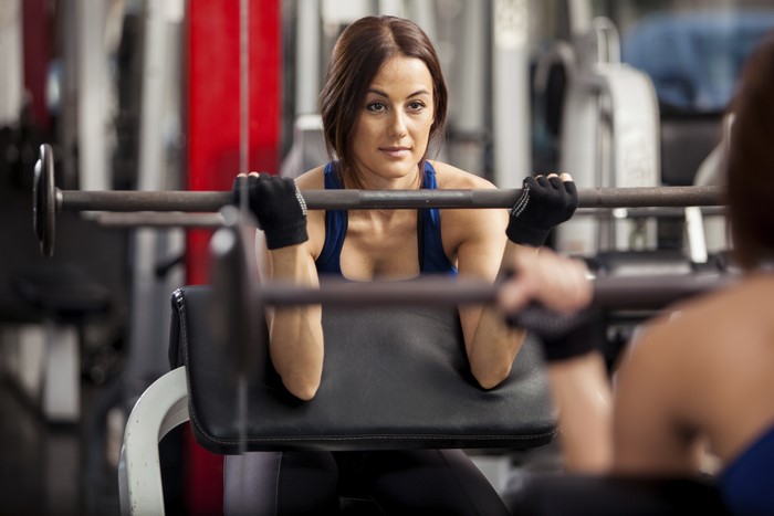 Woman lifting barbell in gym