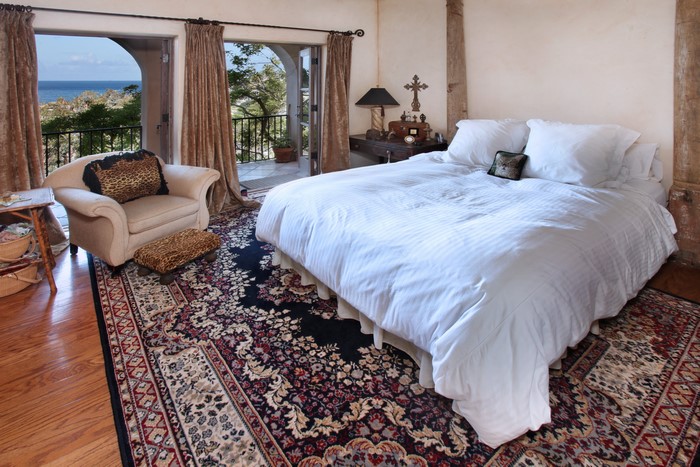 Bedroom with a bed, armchair, and balcony view
