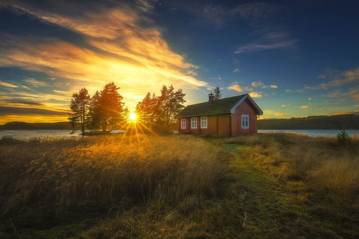 Red house by a lake at sunset in Ringerike, Norway