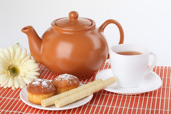Tea set with muffins and a flower