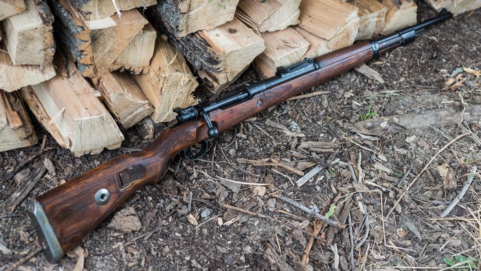 Mauser 98k rifle on a pile of firewood