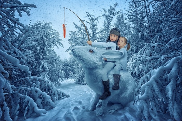 Two girls riding a rabbit in a snowy forest