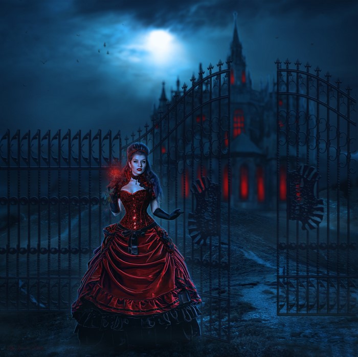 Woman in red dress at night in front of castle gates