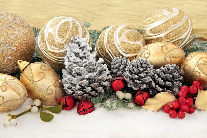 Christmas ornaments, pine cones, and berries on snow
