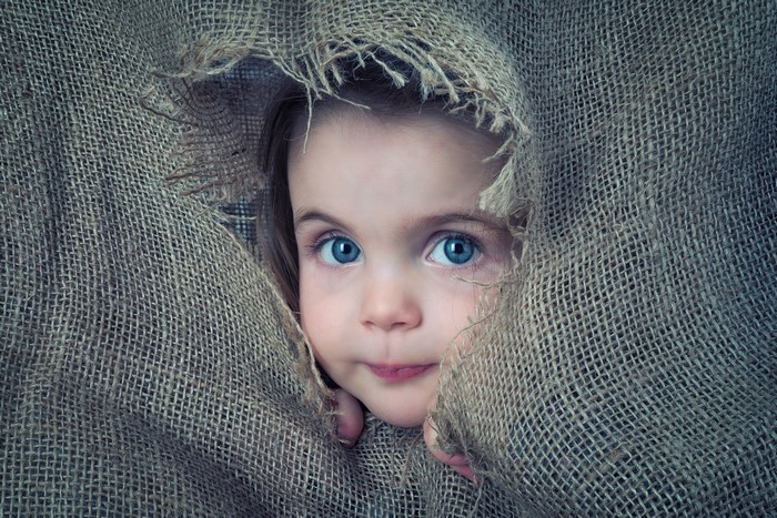 Little girl peeking through burlap