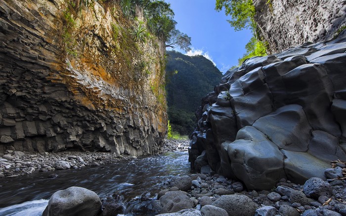 River flowing through a rocky canyon with lush green mountains