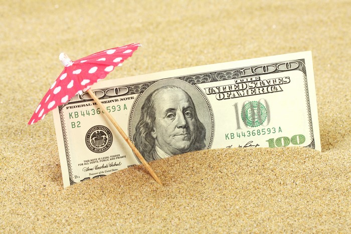 100 Dollar Bill with Umbrella in Sand