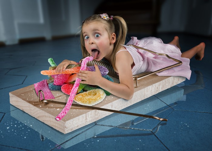 Girl on a mousetrap with candy