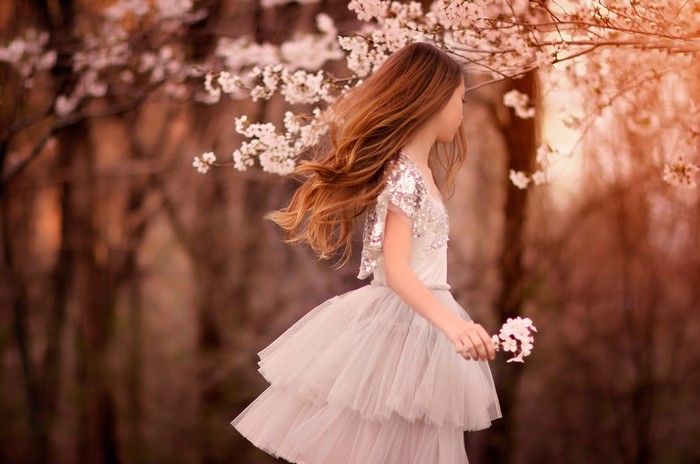 Girl in a dress under flowering trees