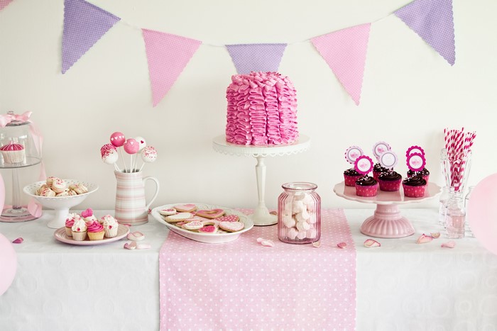 Pink and purple party dessert table with cake and cupcakes