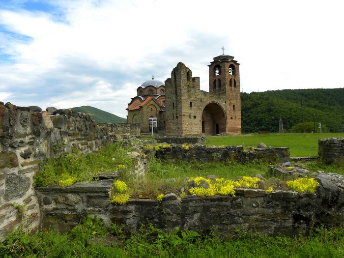 Ruins of a stone church and bell tower in a grassy field