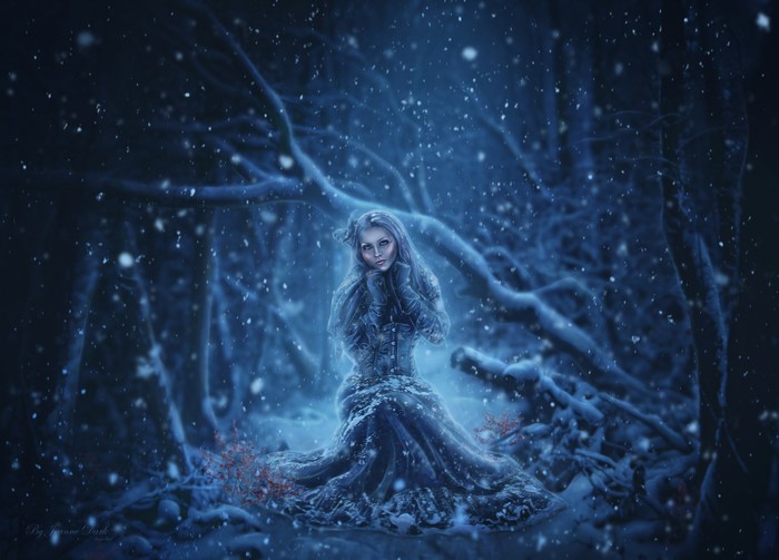 Woman in a blue dress in a snowy forest