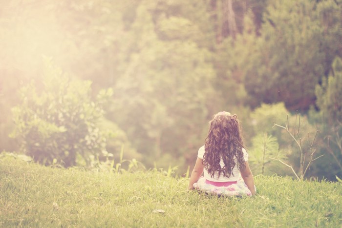 Little girl sitting on grass
