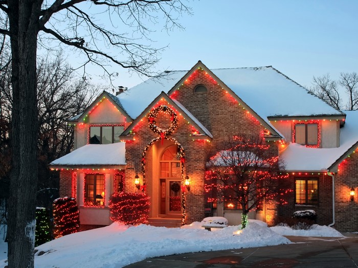 House decorated with Christmas lights in the snow