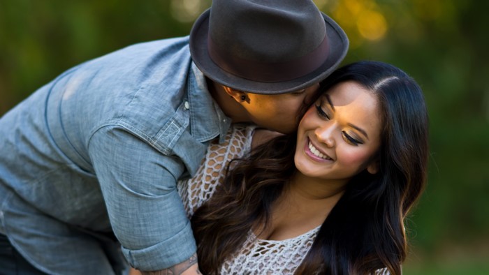 Couple in love, man kissing woman wearing hat