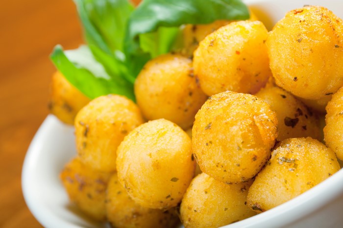Fried potato balls with herbs in a bowl