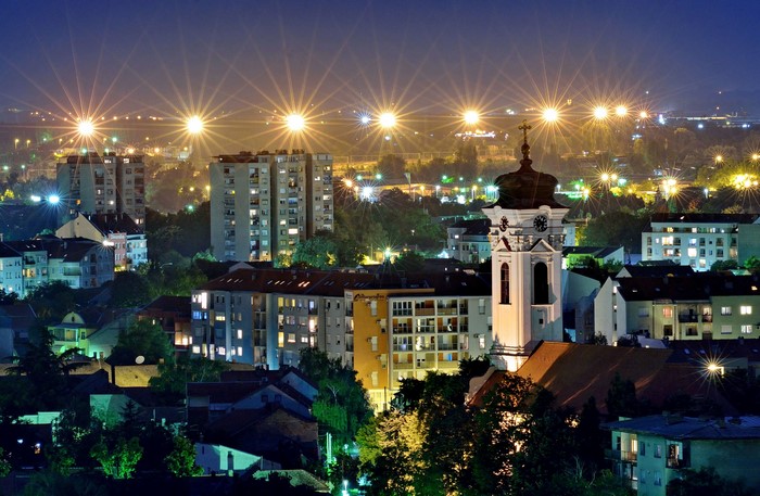Novi Sad cityscape at night with church tower and street lights