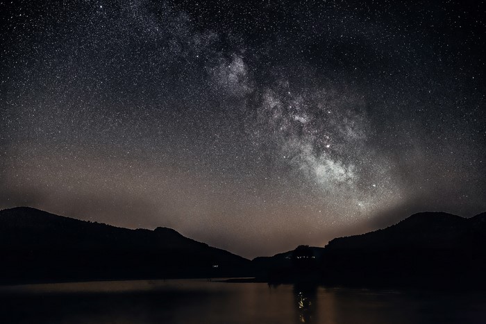 Milky Way over mountains and lake at night
