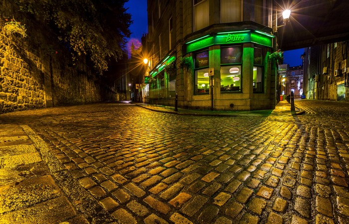 Cobblestone street at night with a bistro in Scotland