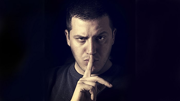 Man with finger on lips