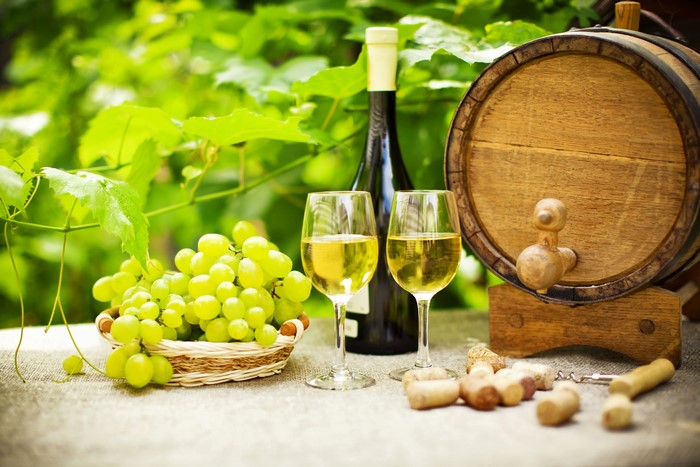 White wine with grapes and barrel