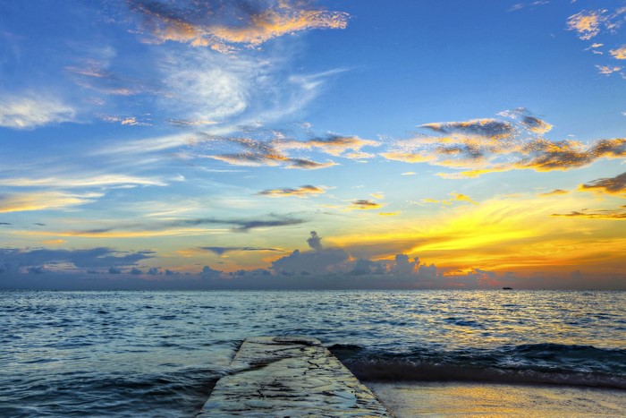 Sunset over the ocean with a pier
